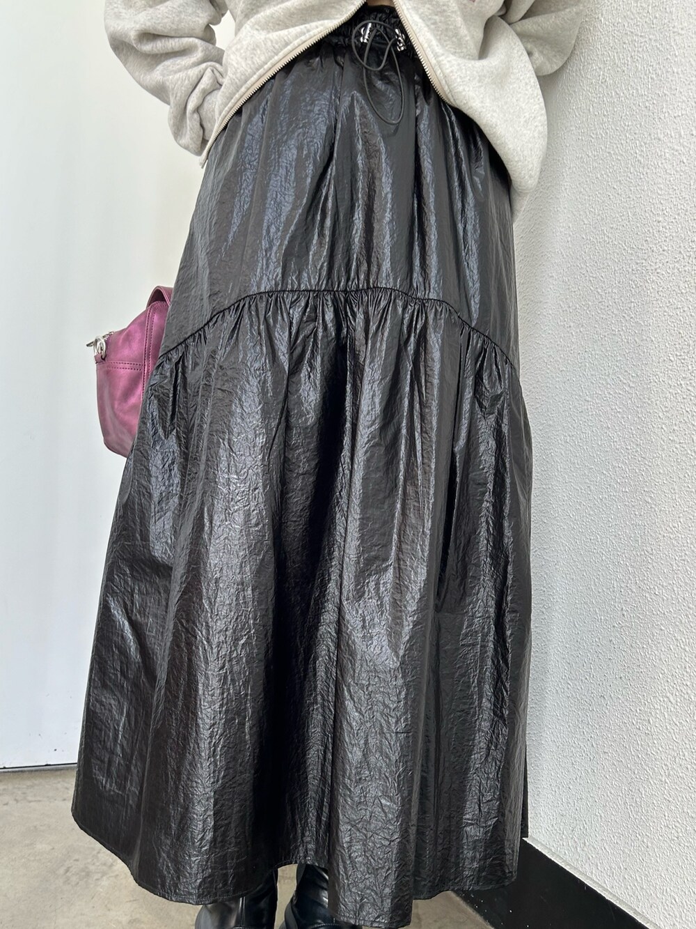 グレー系のスウェット、ブラック系のスカート、パープル系のハンドバッグを着用したレディースの秋コーディネートの8枚目の写真