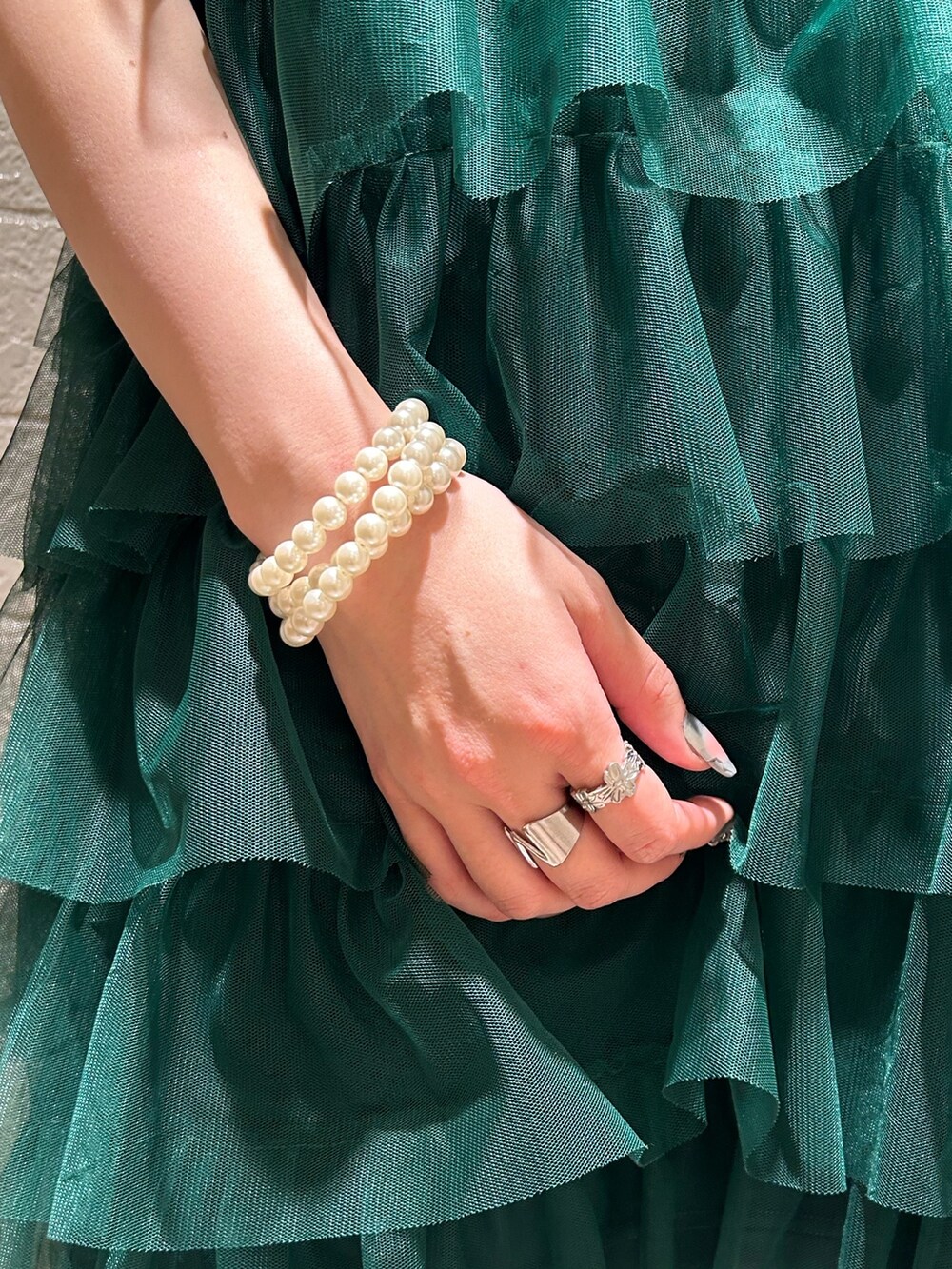 グリーン系のワンピース、ゴールド系のブレスレットを着用したレディースの春コーディネートの10枚目の写真