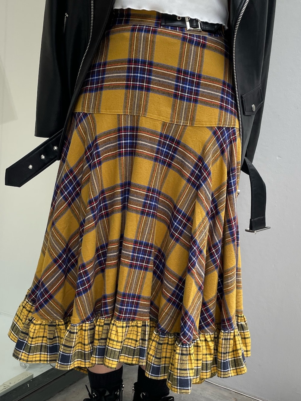 イエロー系のスカート、ブラック系のライダースジャケット、ホワイト系のTシャツ/カットソーを着用したレディースの秋コーディネートの6枚目の写真