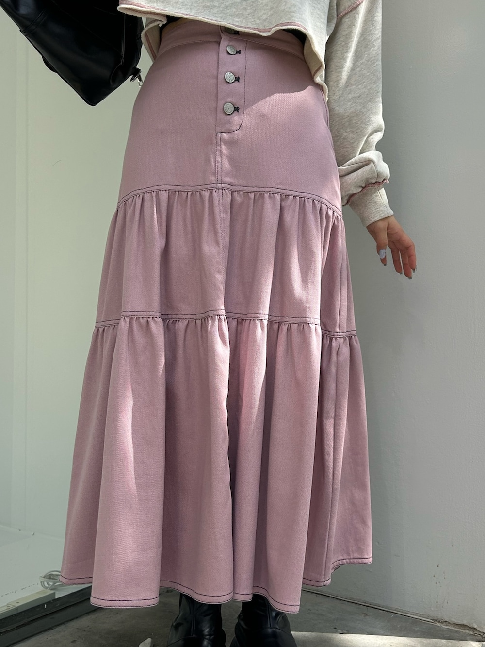 ピンク系のワンピース、ブラック系のハンドバッグ、グレー系のスウェットを着用したレディースの冬コーディネートの7枚目の写真