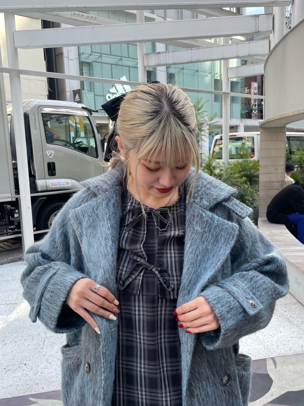 ブルー系のチェスターコート、ブラック系のワンピース、ブラック系のその他シューズを着用したレディースの冬コーディネートの3枚目の写真