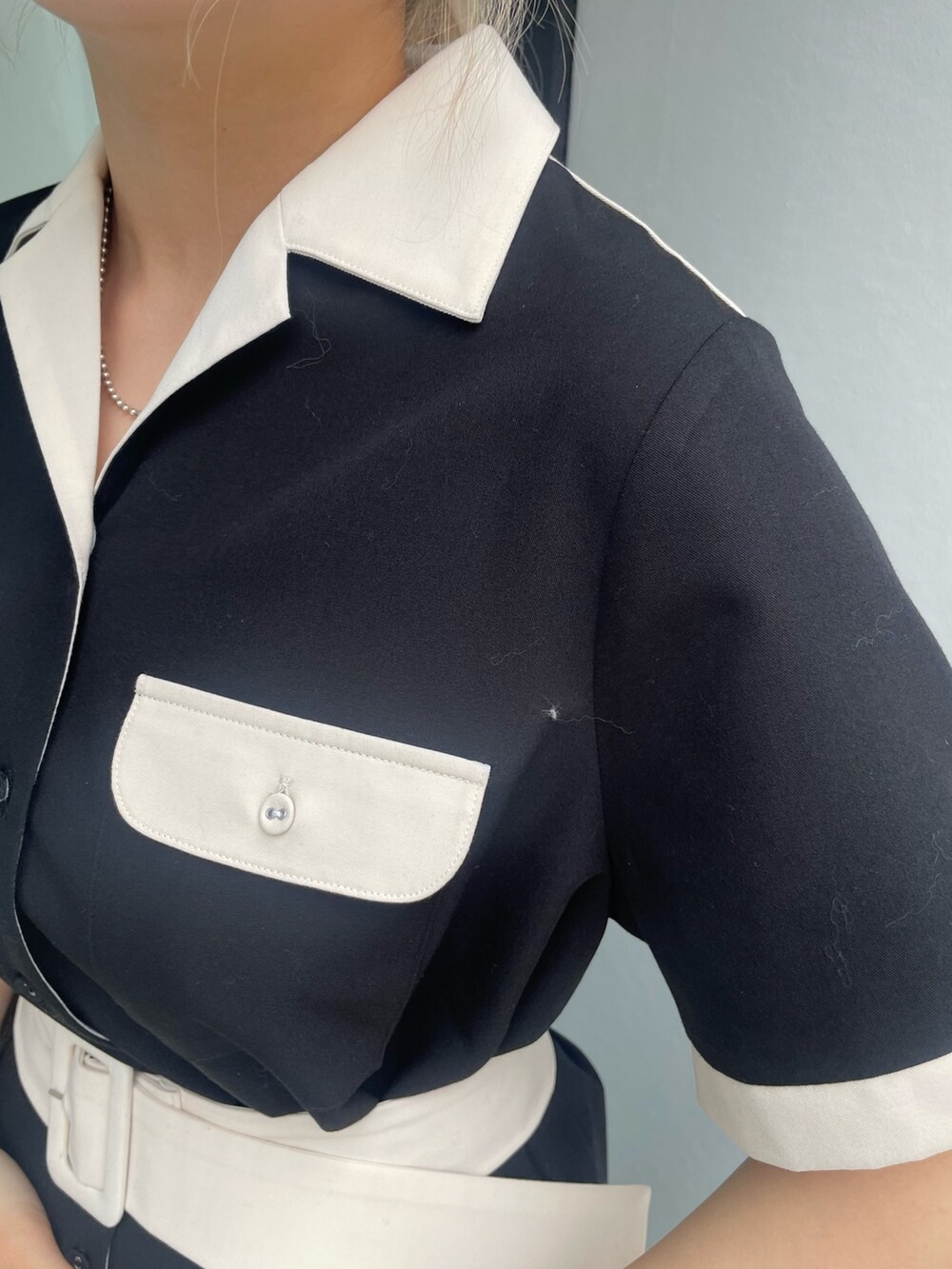 ブラック系のワンピース、ブラック系のサンダル、シルバー系のピアス（両耳用）を着用したレディースの春コーディネートの5枚目の写真