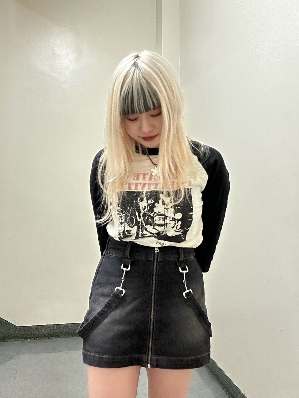 ホワイト系のTシャツ/カットソー、ブラック系のデニムスカート、シルバー系のネックレスを着用したレディースの春コーディネートの5枚目の写真