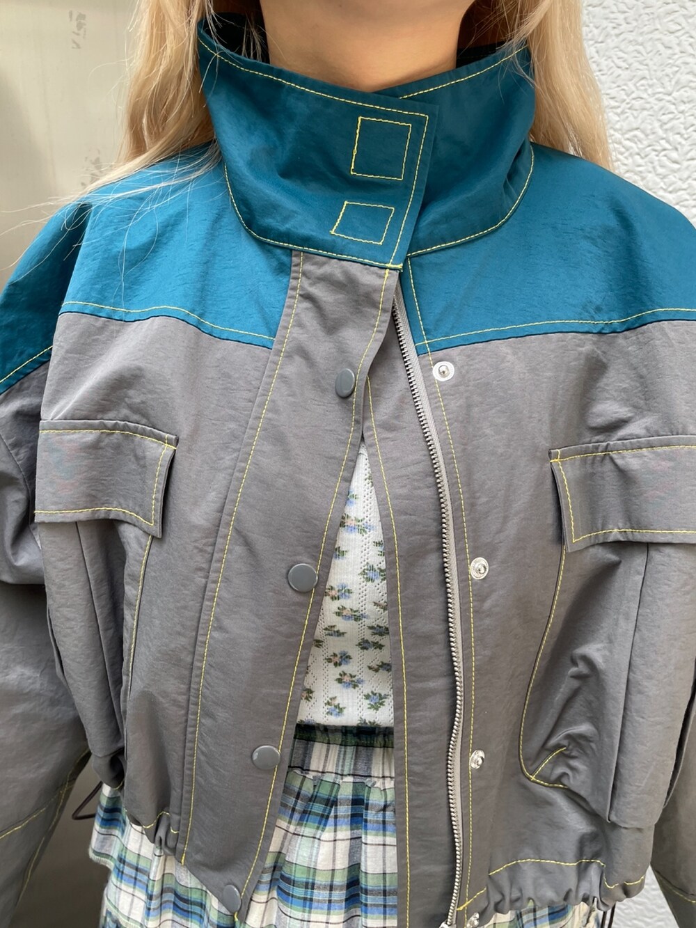 グレー系のブルゾン、グリーン系のスカート、ブラック系のその他シューズを着用したレディースの夏コーディネートの4枚目の写真