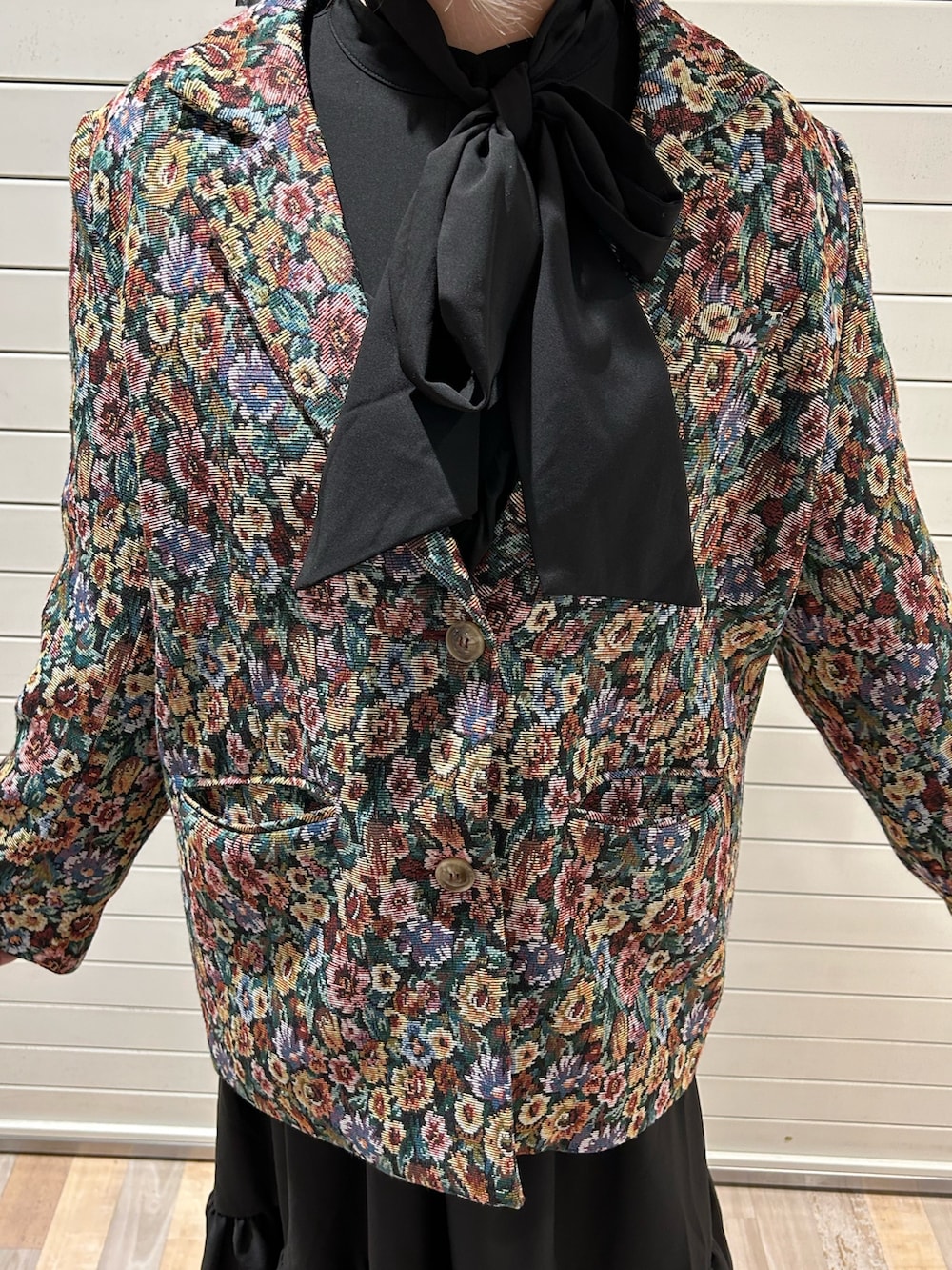 ブラック系のテーラードジャケット、ブラック系のワンピースを着用したレディースの冬コーディネートの5枚目の写真