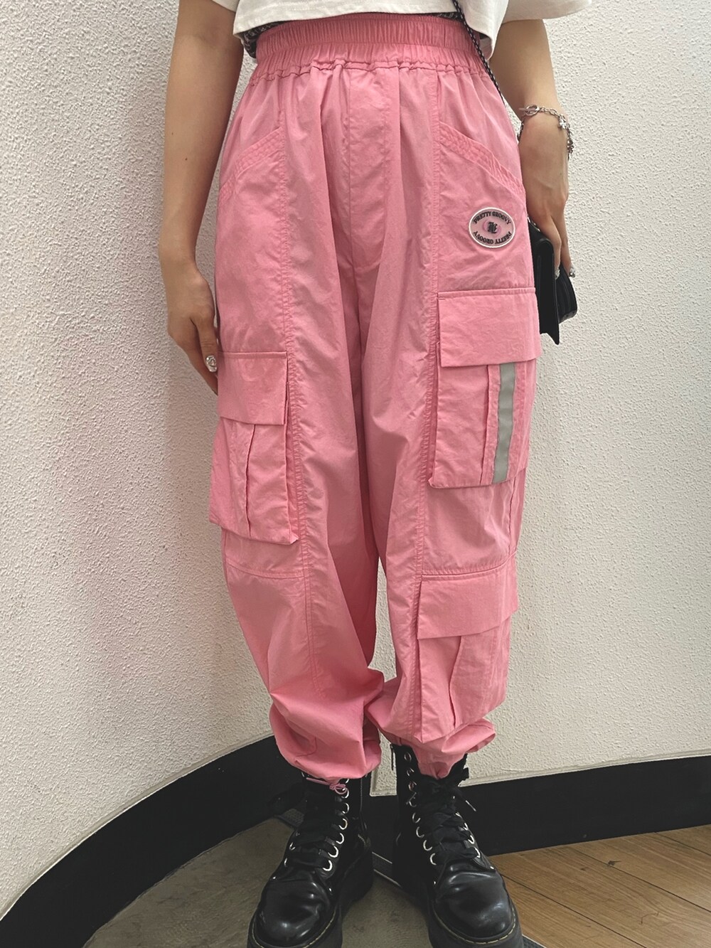 ピンク系のカーゴパンツ、ブラック系のその他シューズ、ホワイト系のTシャツ/カットソーを着用したレディースの春コーディネートの6枚目の写真