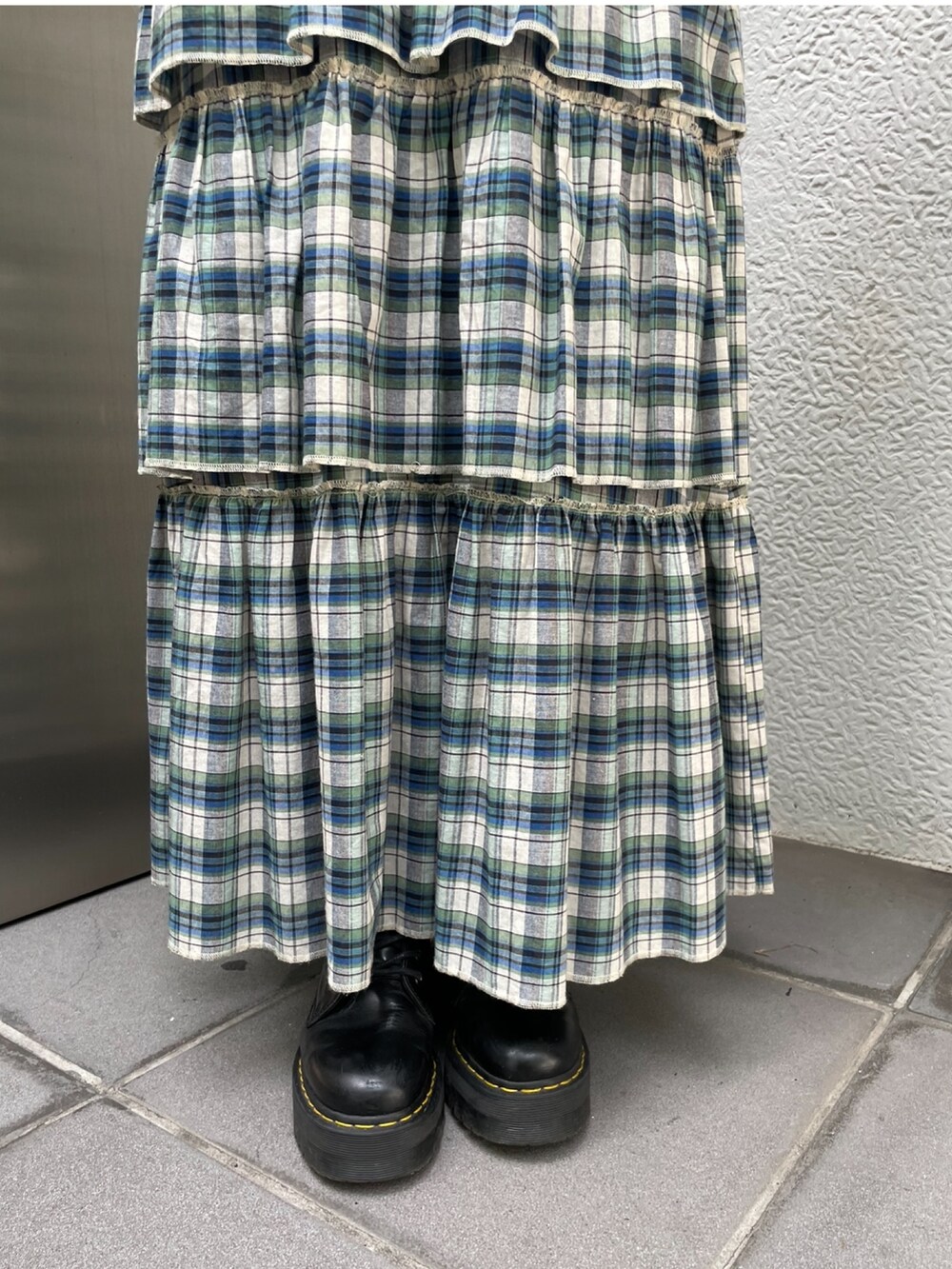 グレー系のブルゾン、グリーン系のスカート、ブラック系のその他シューズを着用したレディースの夏コーディネートの5枚目の写真