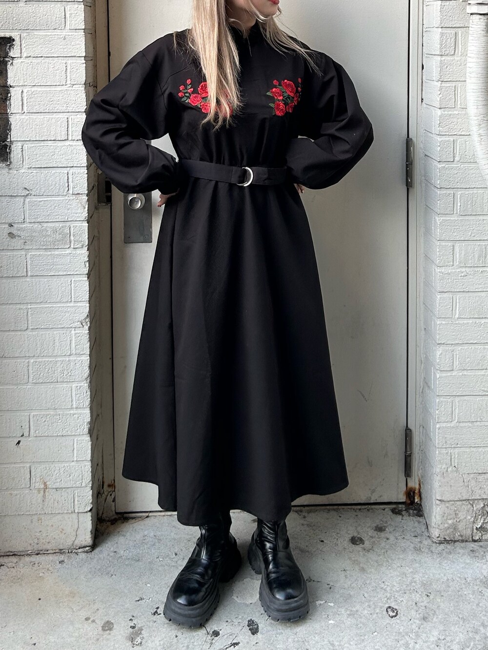 ブラック系のワンピース、ブラック系のブーツを着用したレディースの冬コーディネートの2枚目の写真