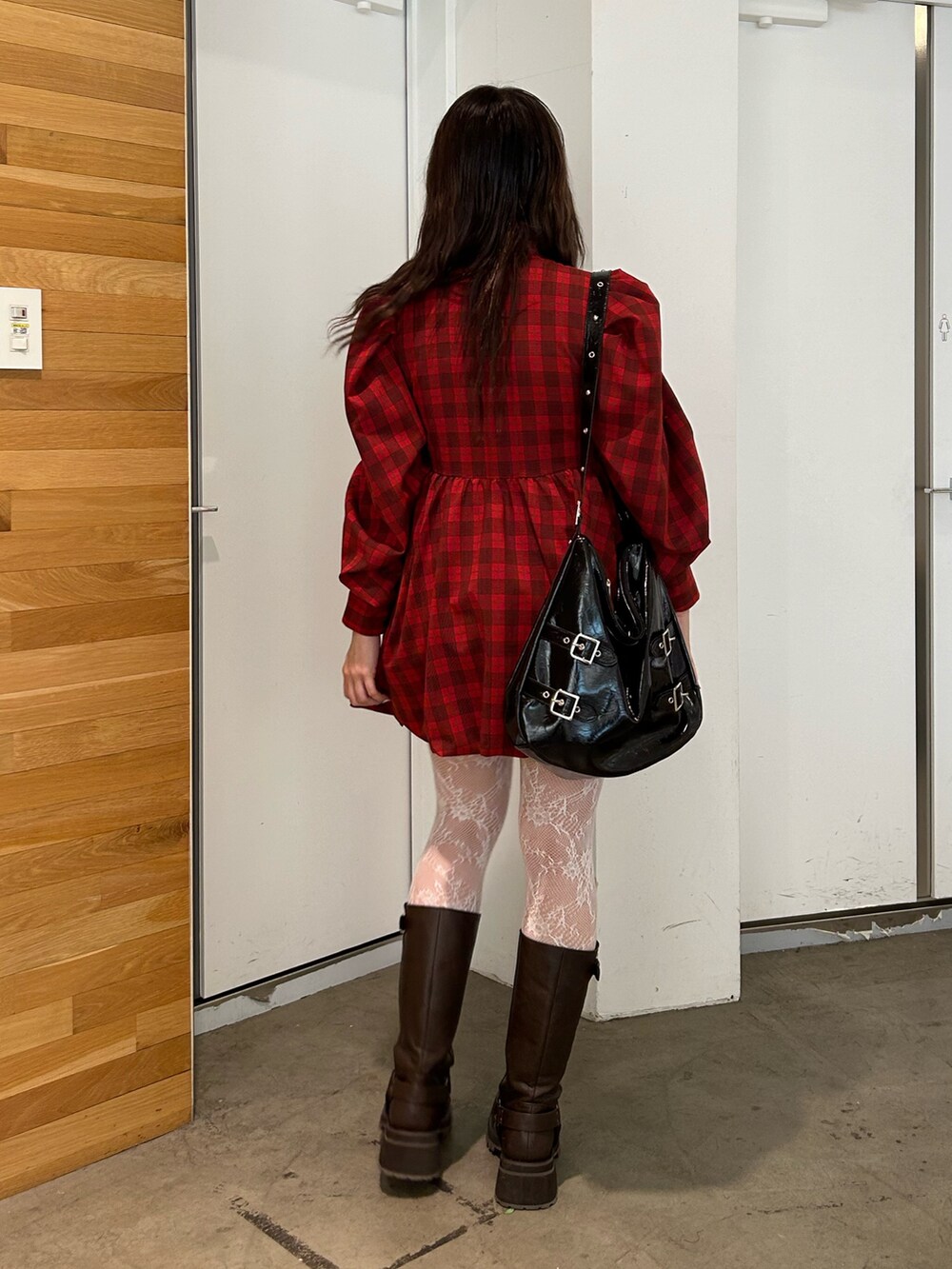 レッド系のワンピース、ブラウン系のブーツ、ブラック系のショルダーバッグを着用したレディースの夏コーディネートの4枚目の写真