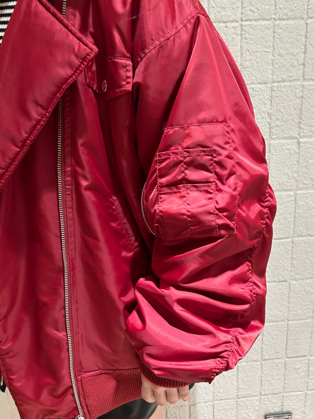 レッド系のMA-1、ブラック系のブーツ、ブラック系のジャンパースカートを着用したレディースの冬コーディネートの9枚目の写真