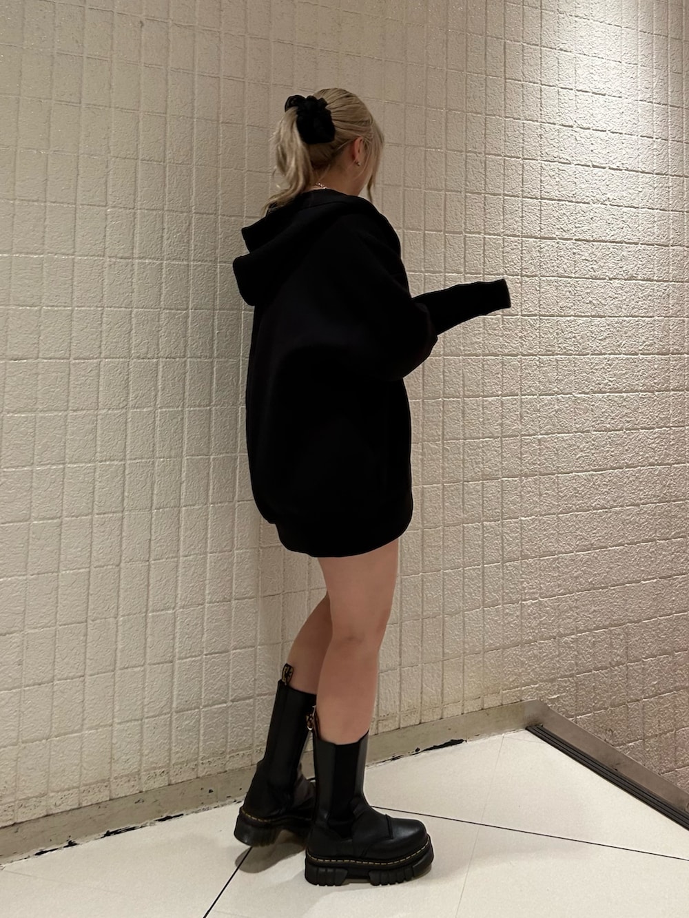 ブラック系のニット/セーター、ブラック系のブーツ、ブラック系のパーカーを着用したレディースの冬コーディネートの2枚目の写真