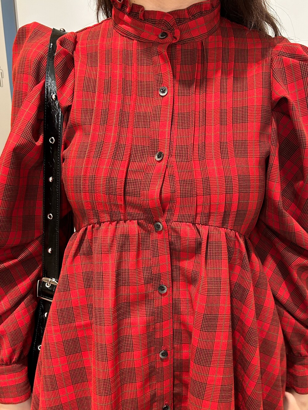 レッド系のワンピース、ブラウン系のブーツ、ブラック系のショルダーバッグを着用したレディースの夏コーディネートの6枚目の写真