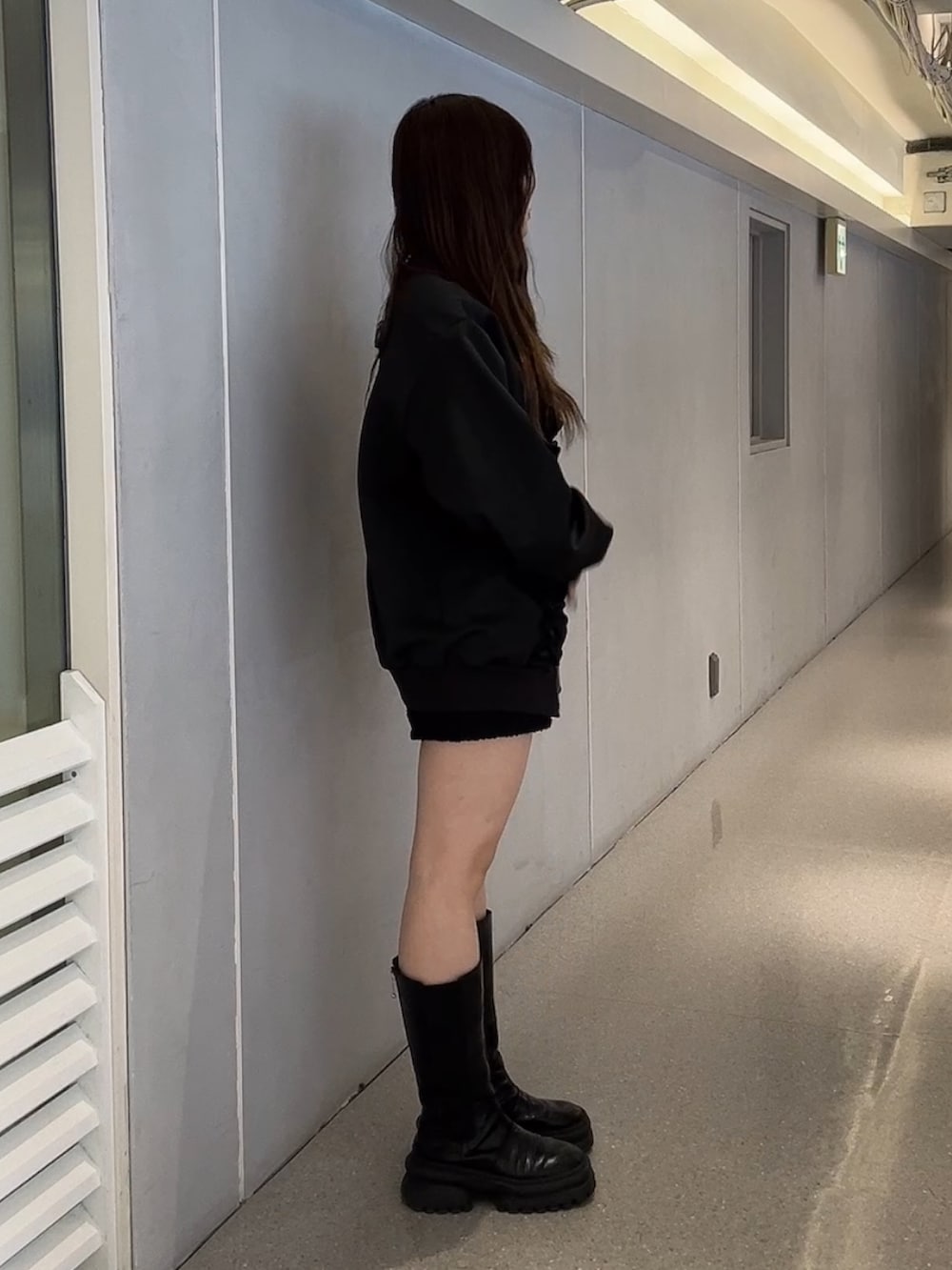 ブラック系のジャージ、ホワイト系のハンドバッグを着用したレディースの冬コーディネートの2枚目の写真