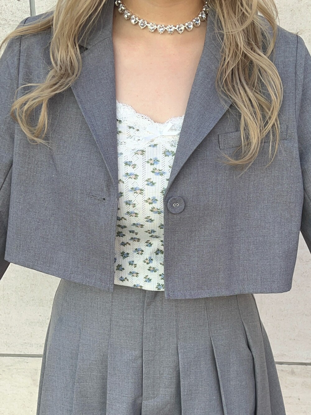 グレー系のテーラードジャケット、グレー系のスカート、ブラック系のブーツを着用したレディースの冬コーディネートの4枚目の写真