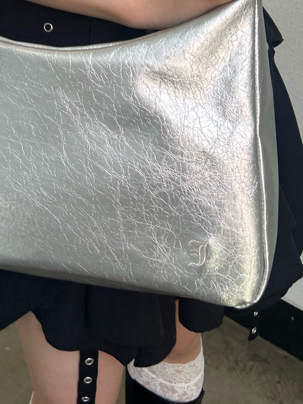 ホワイト系のTシャツ/カットソー、ブラック系のスカート、シルバー系のショルダーバッグを着用したレディースの春コーディネートの7枚目の写真