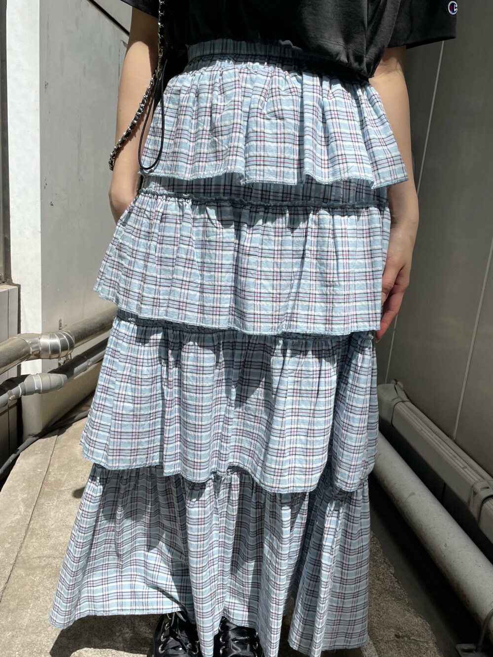 ブラック系のTシャツ/カットソー、ブラック系のトートバッグ、ブルー系のスカートを着用したレディースの春コーディネートの8枚目の写真