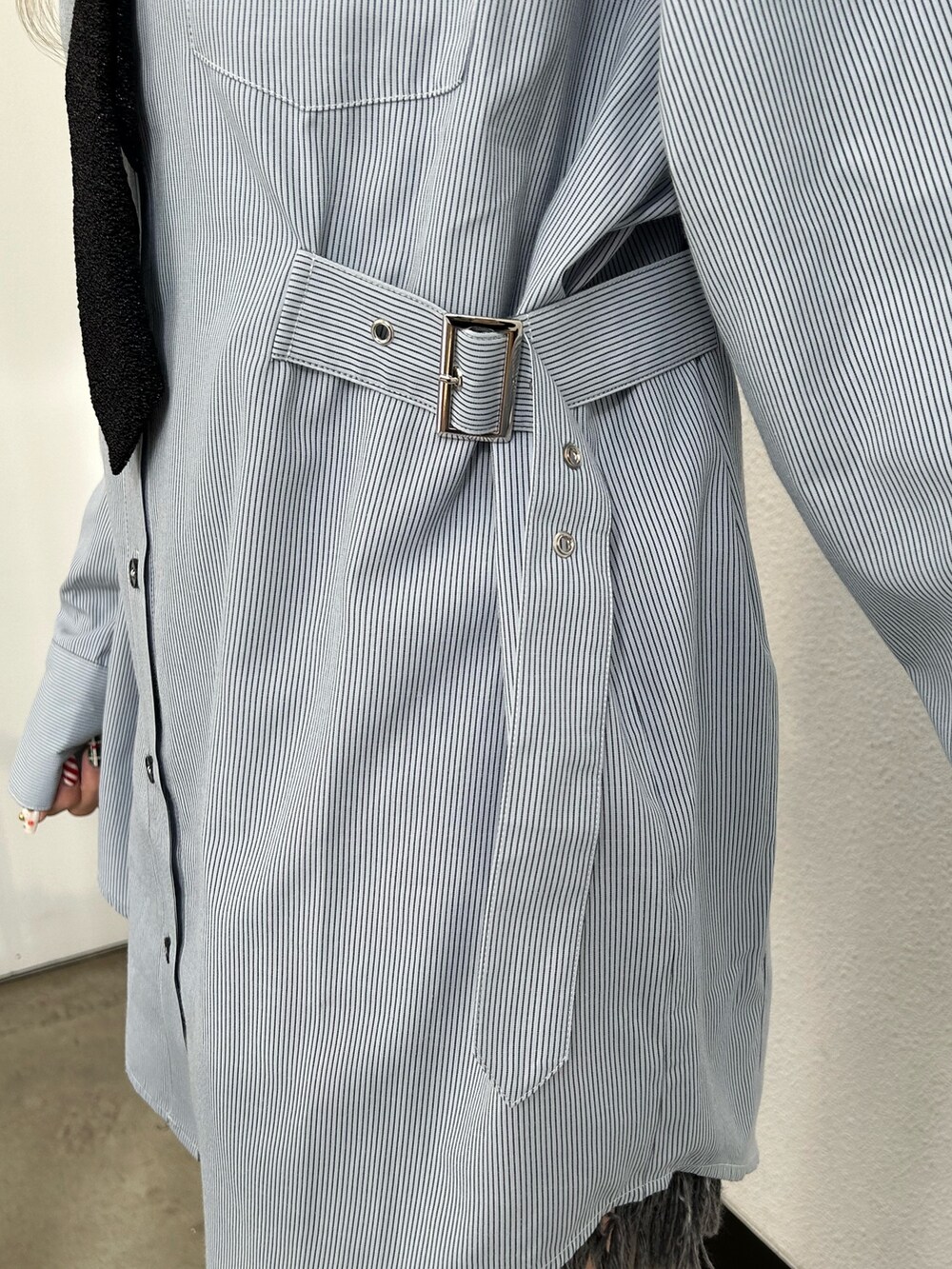 ブルー系のシャツ/ブラウス、ブラック系のデニムパンツ、ブラック系のブーツを着用したレディースの冬コーディネートの6枚目の写真