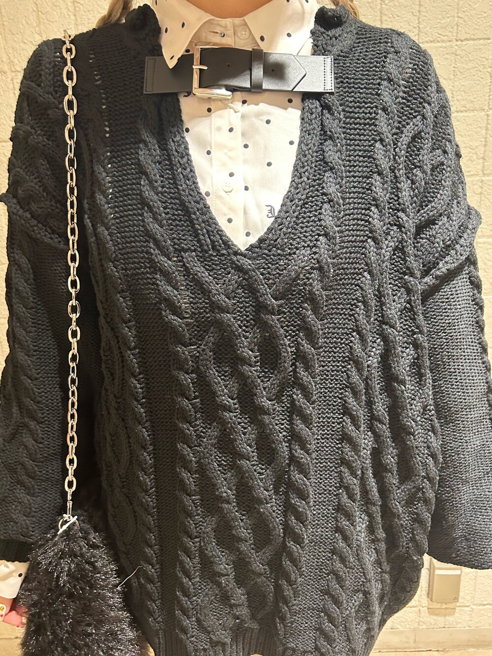 ブラック系のニット/セーター、ブラック系のブーツ、ホワイト系のシャツ/ブラウスを着用したレディースの冬コーディネートの6枚目の写真