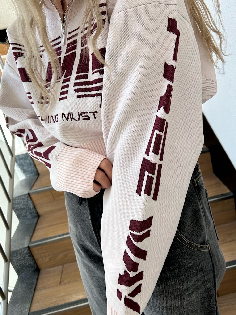 ピンク系のニット/セーター、ブラック系のデニムパンツ、ブラック系のその他シューズを着用したレディースの冬コーディネートの7枚目の写真