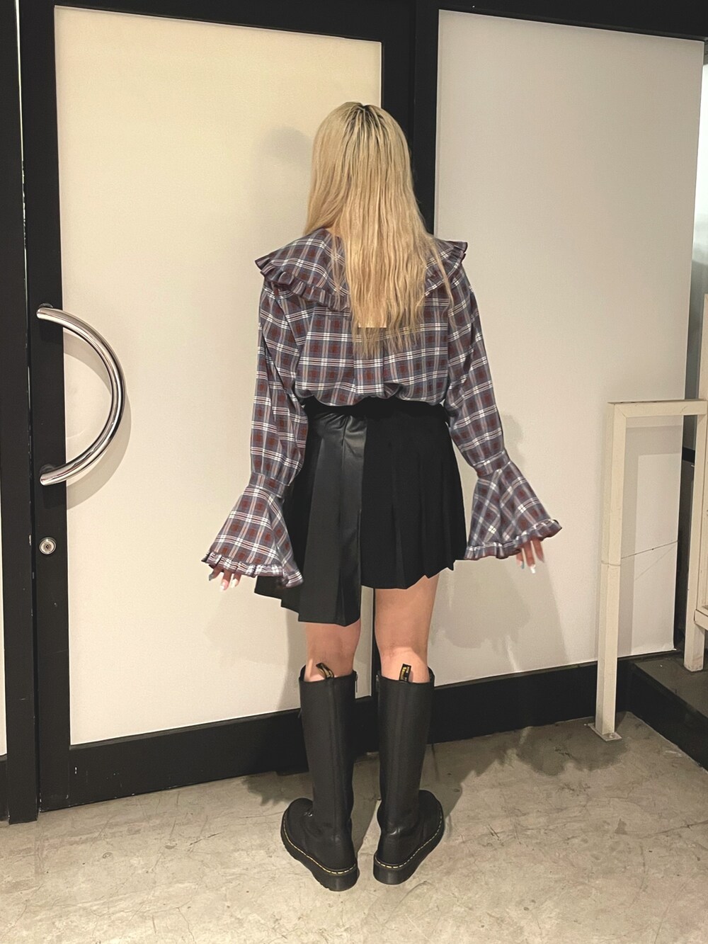 ブラウン系のシャツ/ブラウス、ブラック系のスカート、ブラック系のブーツを着用したレディースの秋コーディネートの2枚目の写真