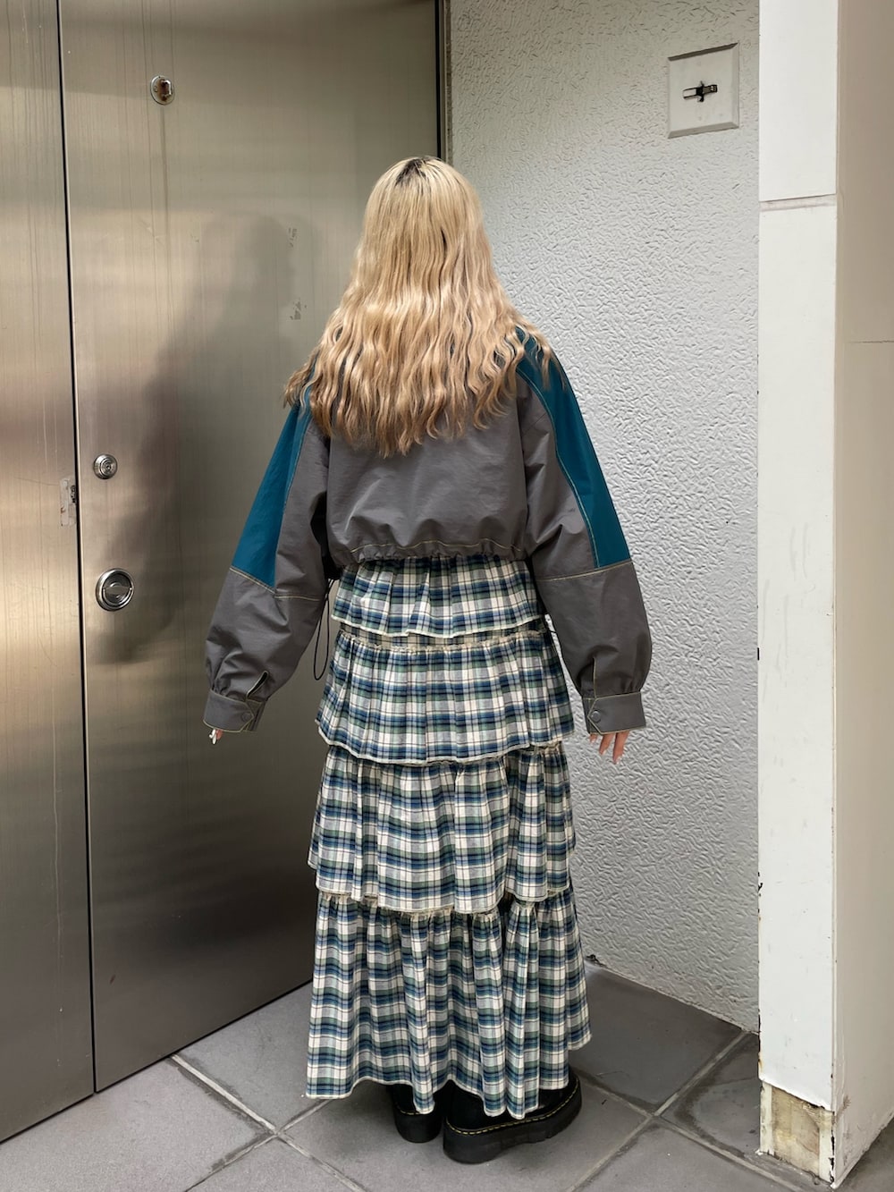 グレー系のブルゾン、グリーン系のスカート、ブラック系のその他シューズを着用したレディースの夏コーディネートの2枚目の写真