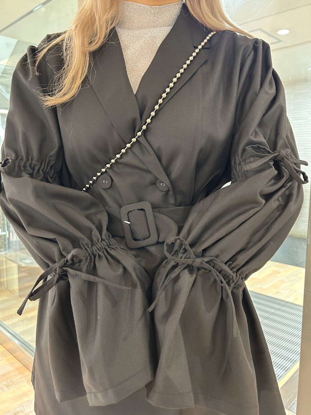 ブラック系のワンピース、シルバー系のTシャツ/カットソー、ホワイト系のショルダーバッグを着用したレディースの秋コーディネートの6枚目の写真