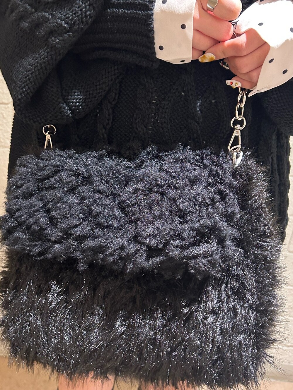 ブラック系のニット/セーター、ブラック系のブーツ、ホワイト系のシャツ/ブラウスを着用したレディースの冬コーディネートの8枚目の写真