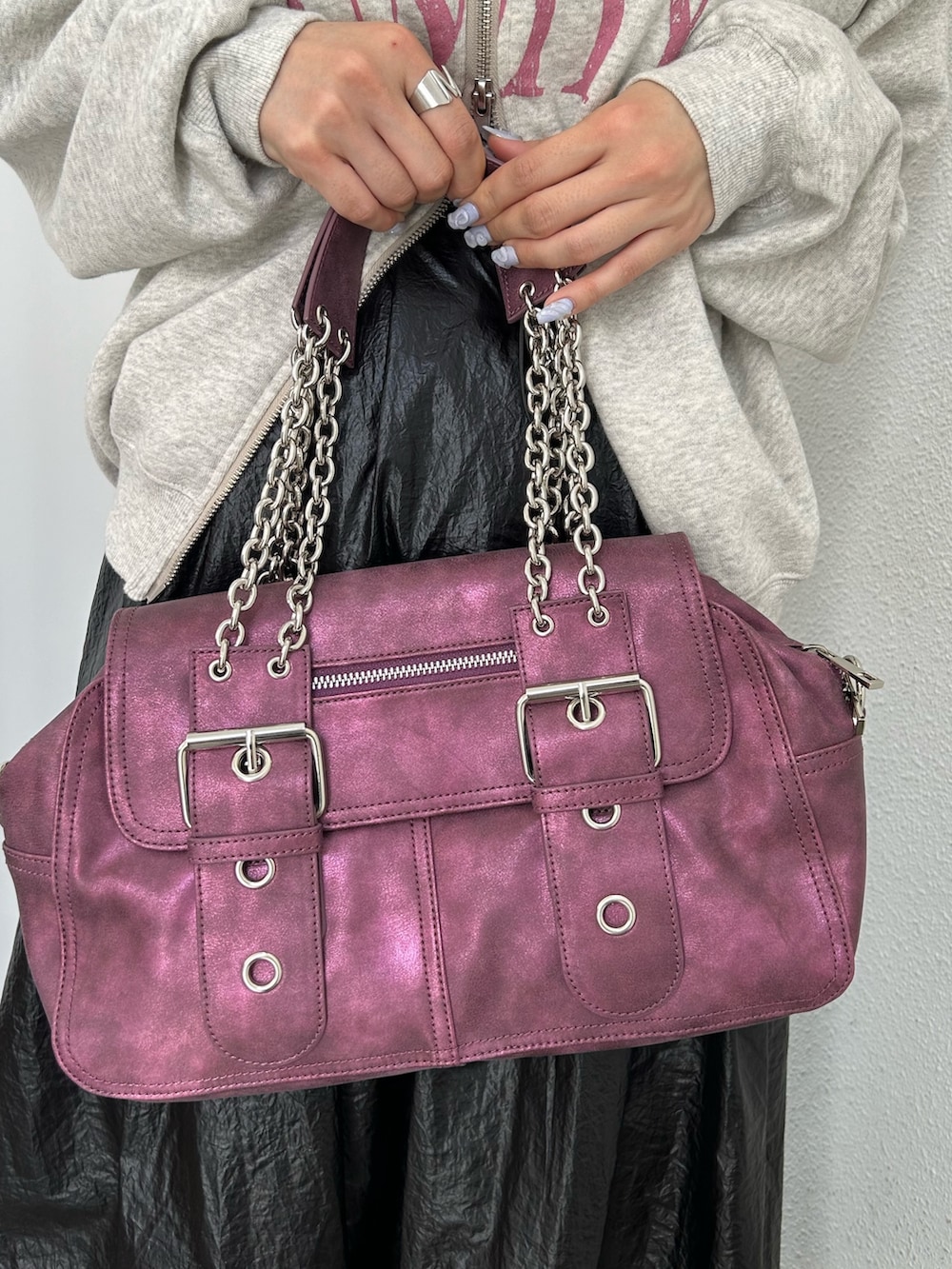 グレー系のスウェット、ブラック系のスカート、パープル系のハンドバッグを着用したレディースの秋コーディネートの9枚目の写真