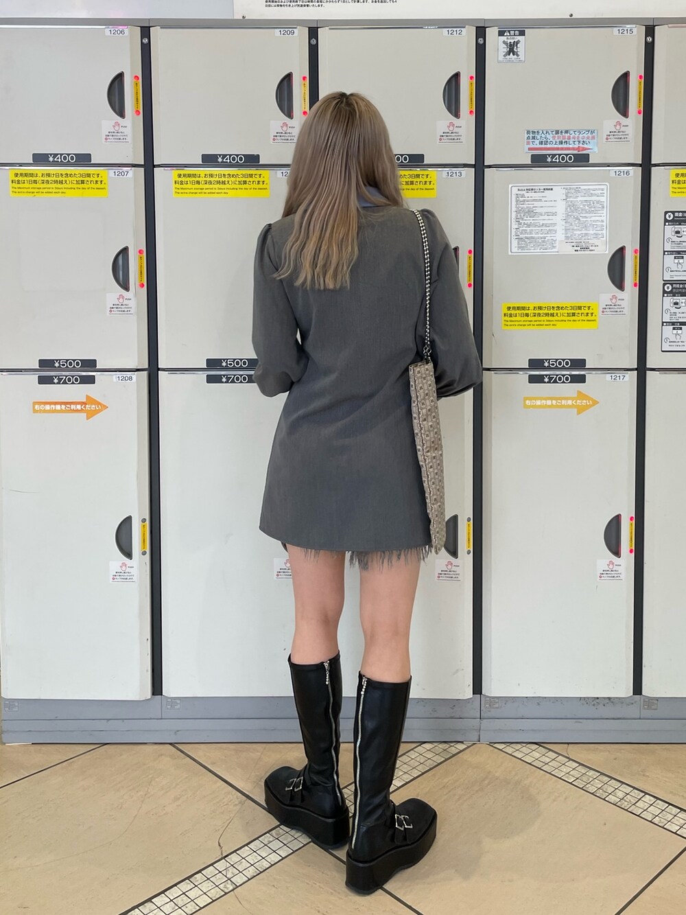 ベージュ系のトートバッグ、グレー系のワンピース、ブラック系のブーツを着用したレディースの冬コーディネートの3枚目の写真