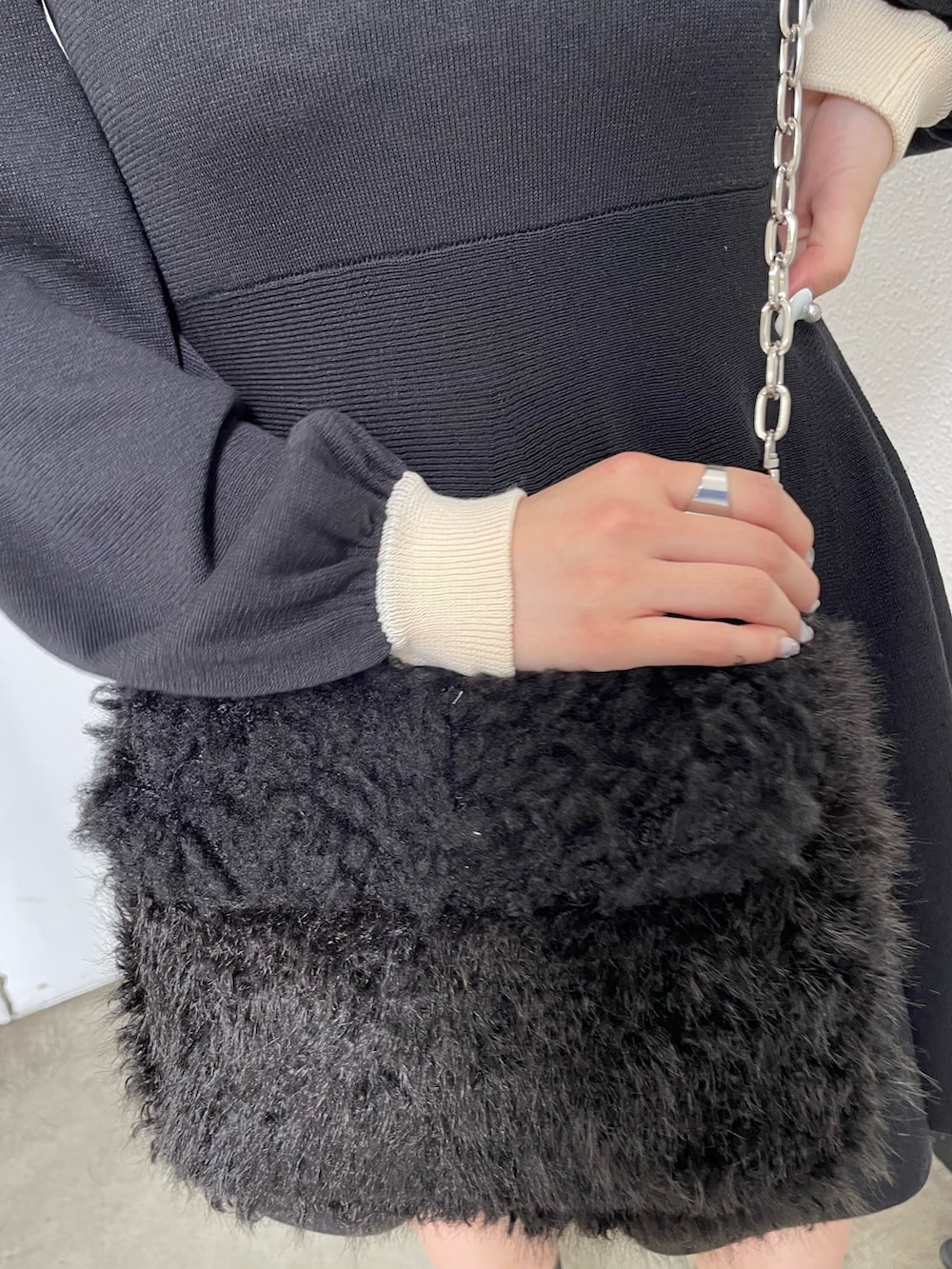 ブラック系のワンピース、ブラック系のハンドバッグを着用したレディースの夏コーディネートの5枚目の写真