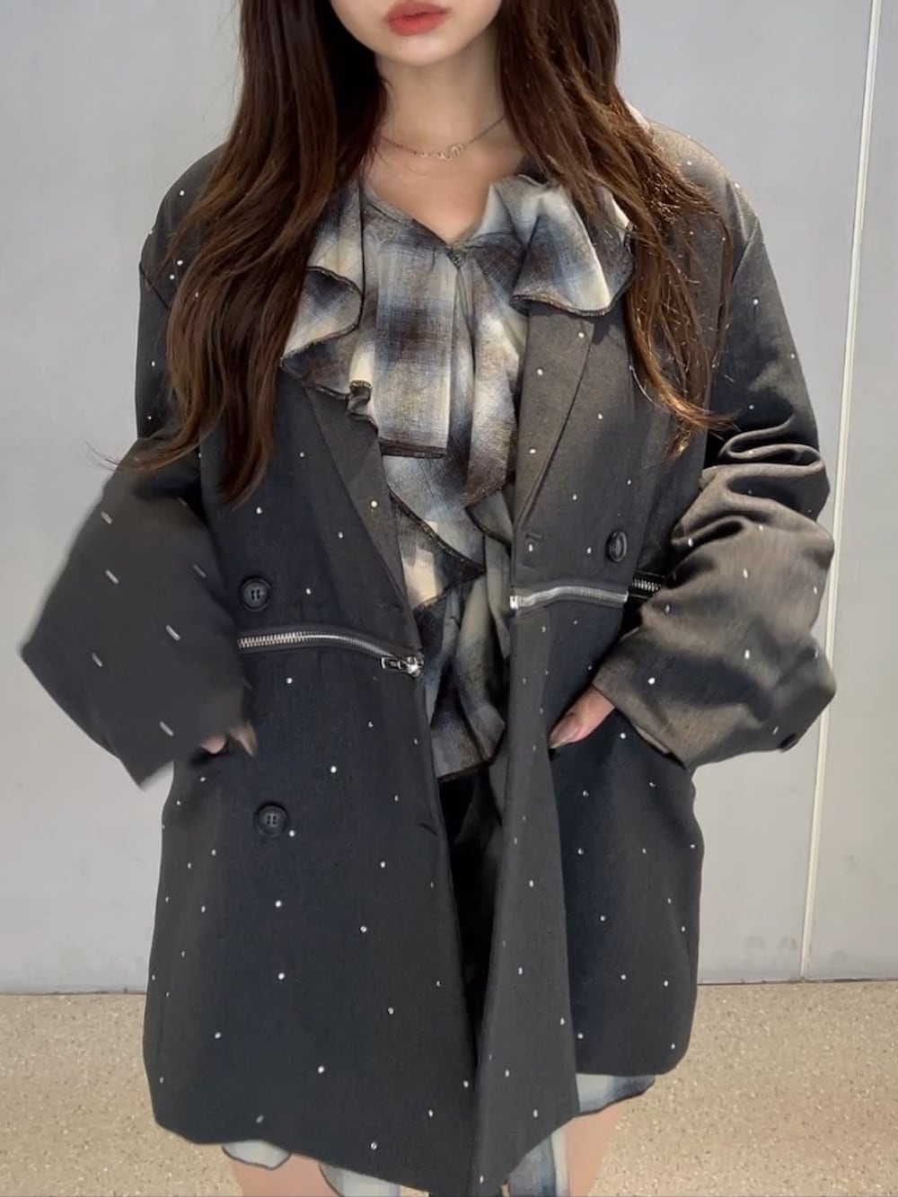 グレー系のテーラードジャケット、ブラウン系のワンピース、ブラック系のブーツを着用したレディースの秋コーディネートの6枚目の写真