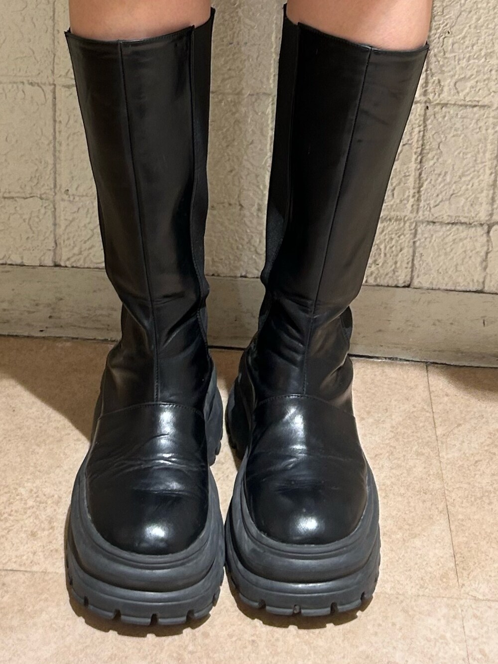 レッド系のニット/セーター、ブラック系のデニムパンツ、ブラック系のブーツを着用したレディースの冬コーディネートの7枚目の写真