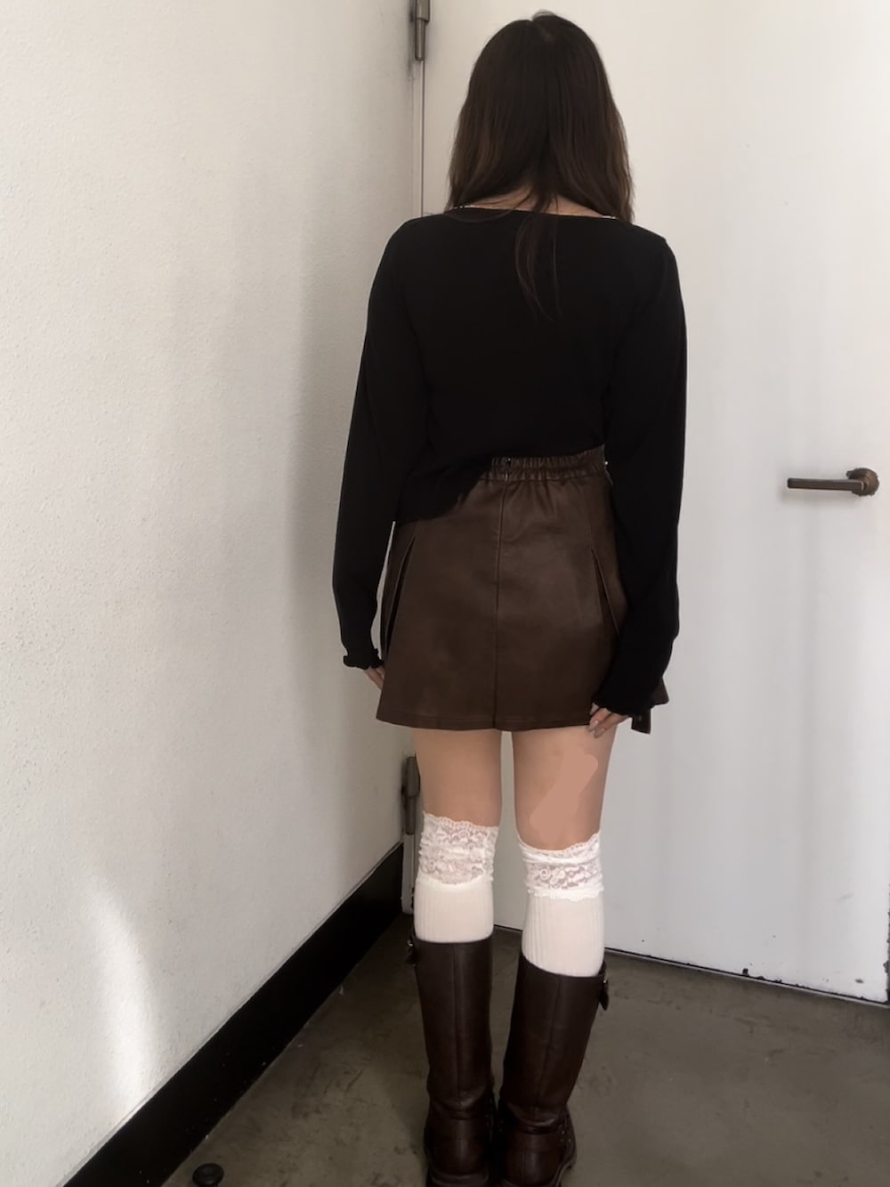 ブラック系のTシャツ/カットソー、ブラウン系のスカート、ブラウン系のブーツを着用したレディースの秋コーディネートの3枚目の写真