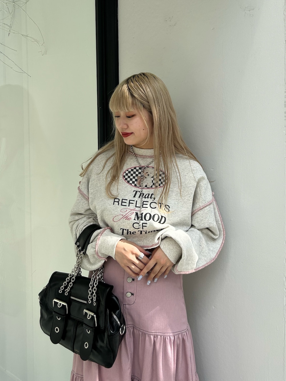 ピンク系のワンピース、ブラック系のハンドバッグ、グレー系のスウェットを着用したレディースの冬コーディネートの4枚目の写真