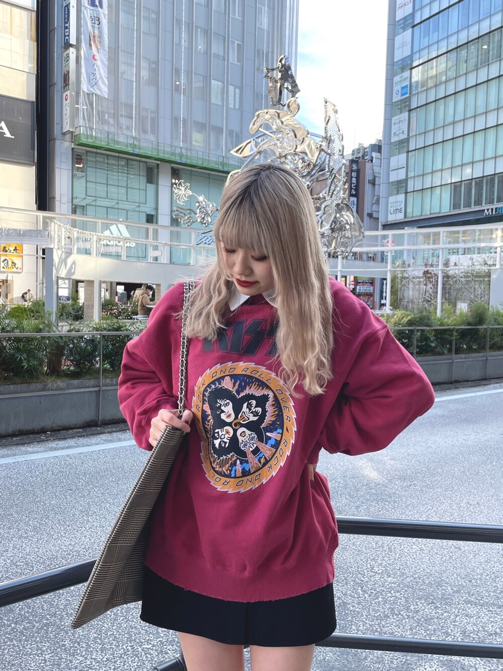 レッド系のスウェット、ブラック系のワンピース、ベージュ系のトートバッグを着用したレディースの冬コーディネートの4枚目の写真