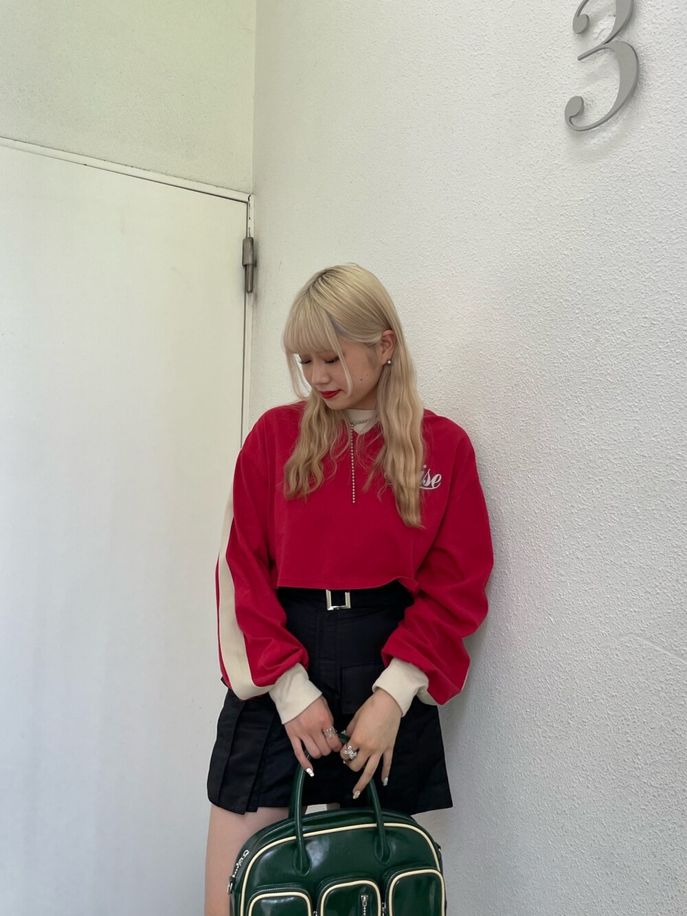 レッド系のTシャツ/カットソー、ブラック系のその他パンツ、グリーン系のボストンバッグを着用したレディースの夏コーディネートの3枚目の写真