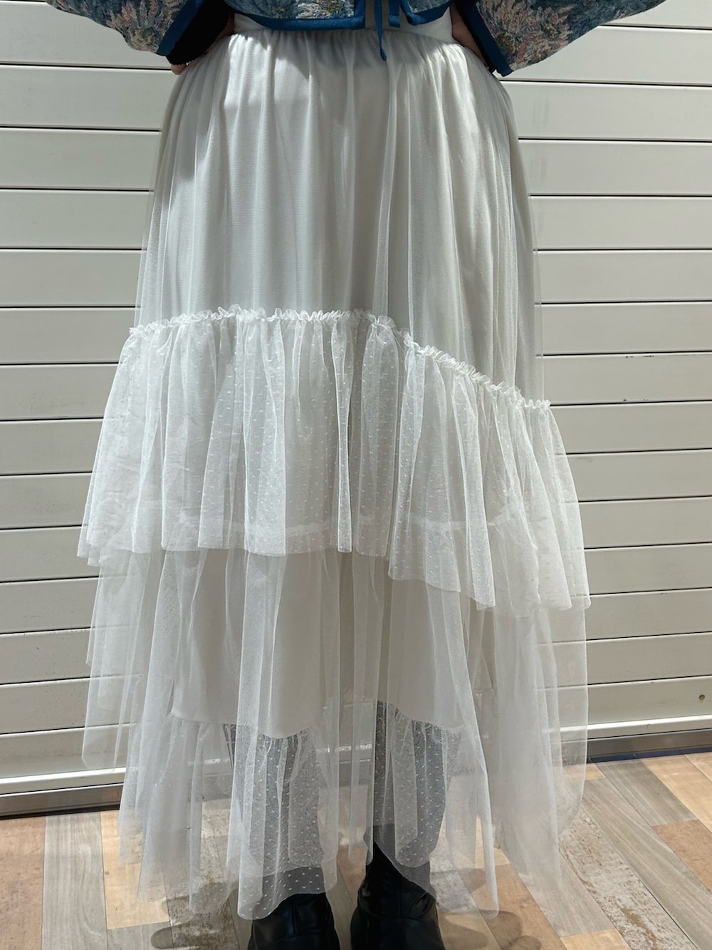 ブラック系のニット/セーター、ブルー系のノーカラージャケット、ホワイト系のスカートを着用したレディースの冬コーディネートの7枚目の写真