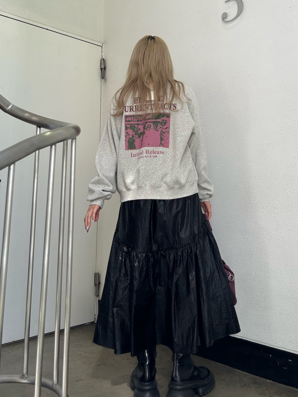 グレー系のスウェット、ブラック系のスカート、パープル系のハンドバッグを着用したレディースの秋コーディネートの4枚目の写真