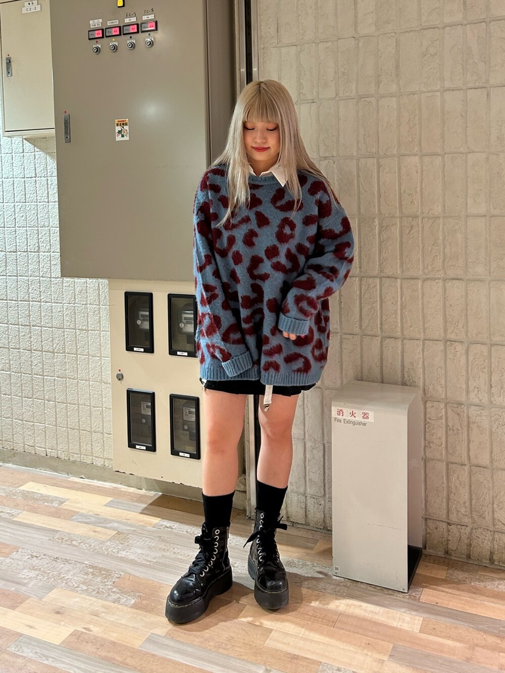 ホワイト系のシャツ/ブラウス、ブルー系のニット/セーター、ブラック系のスカートを着用したレディースの秋コーディネートの2枚目の写真