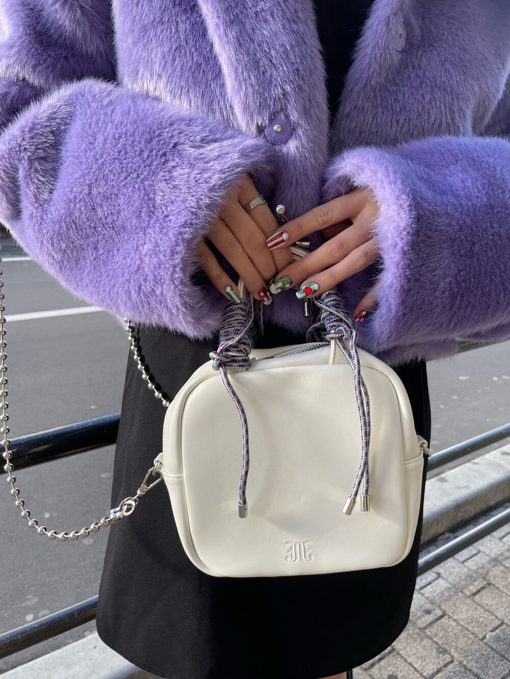 パープル系のその他アウター、ブラック系のワンピース、ブラック系のブーツを着用したレディースの冬コーディネートの7枚目の写真