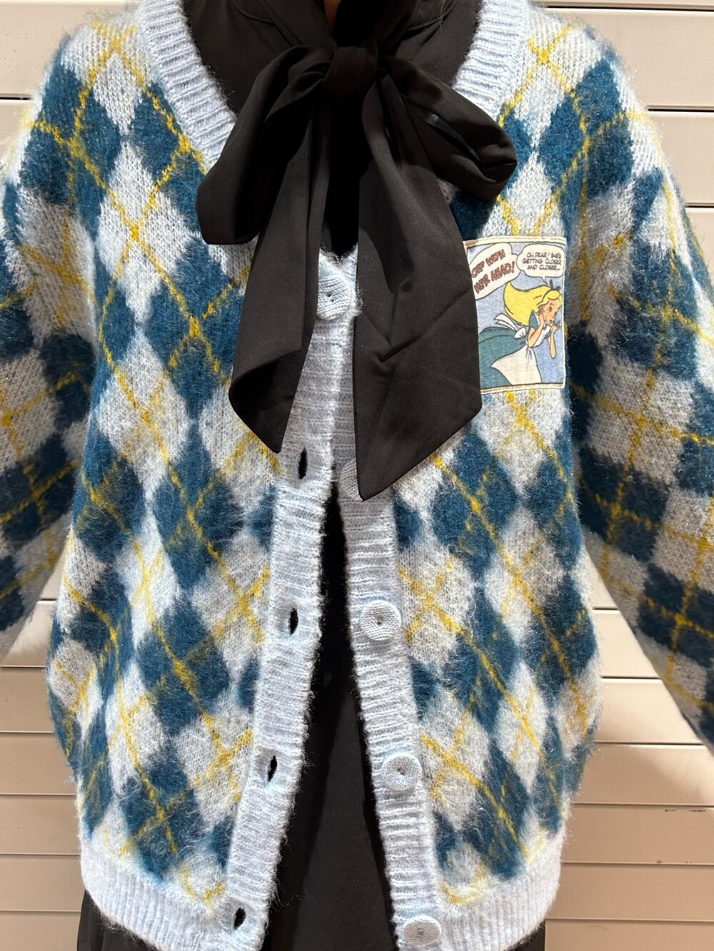 ブラック系のブーツ、ブルー系のカーディガン/ボレロ、ブラック系のワンピースを着用したレディースの秋コーディネートの7枚目の写真