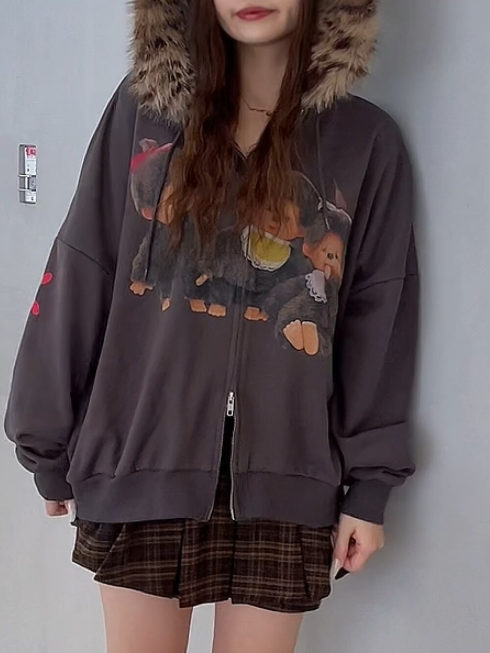 ブラウン系のスカート、ブラック系のパーカー、ブラック系のブーツを着用したレディースの秋コーディネートの5枚目の写真