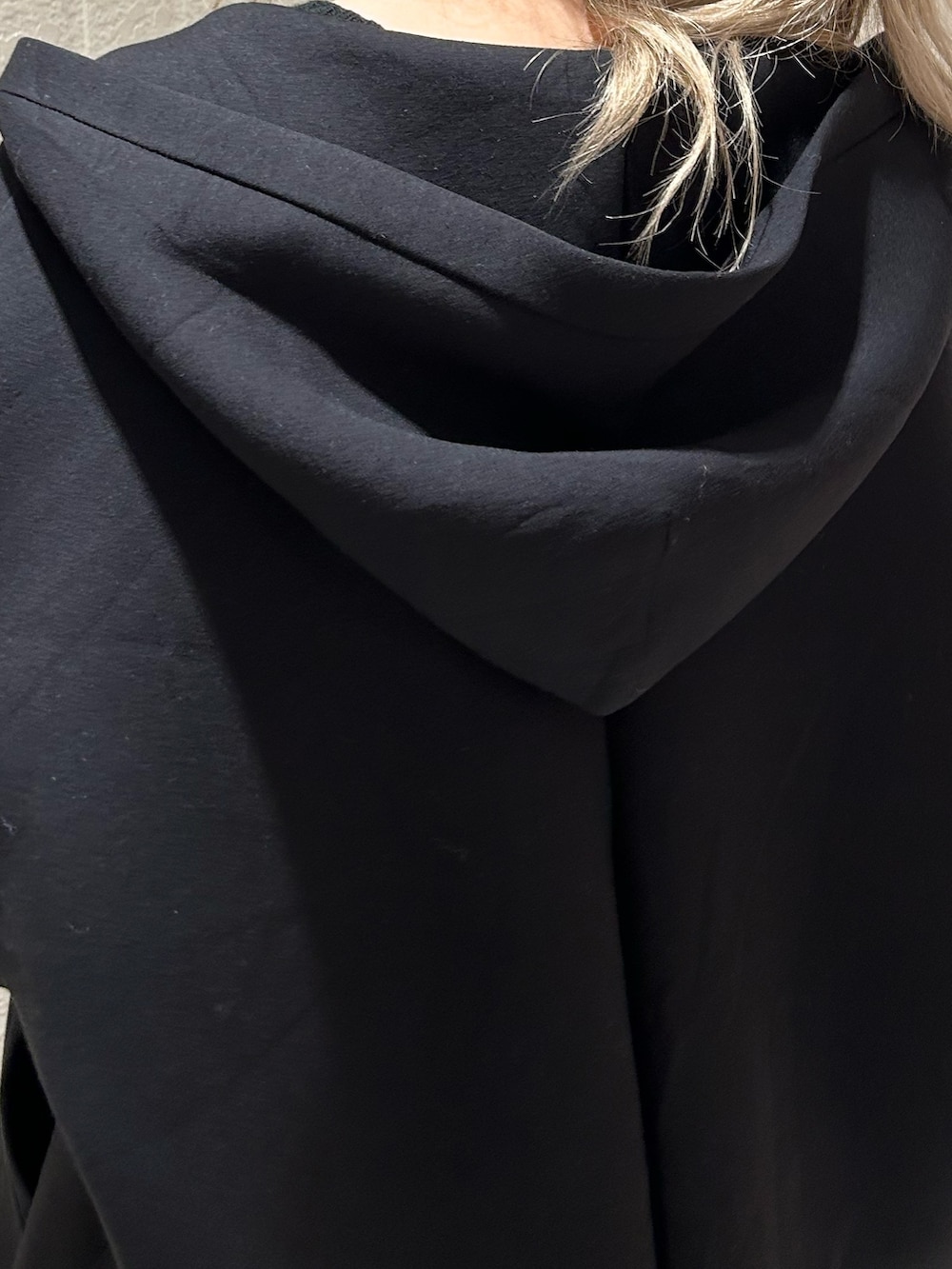 ブラック系のニット/セーター、ブラック系のブーツ、ブラック系のパーカーを着用したレディースの冬コーディネートの7枚目の写真