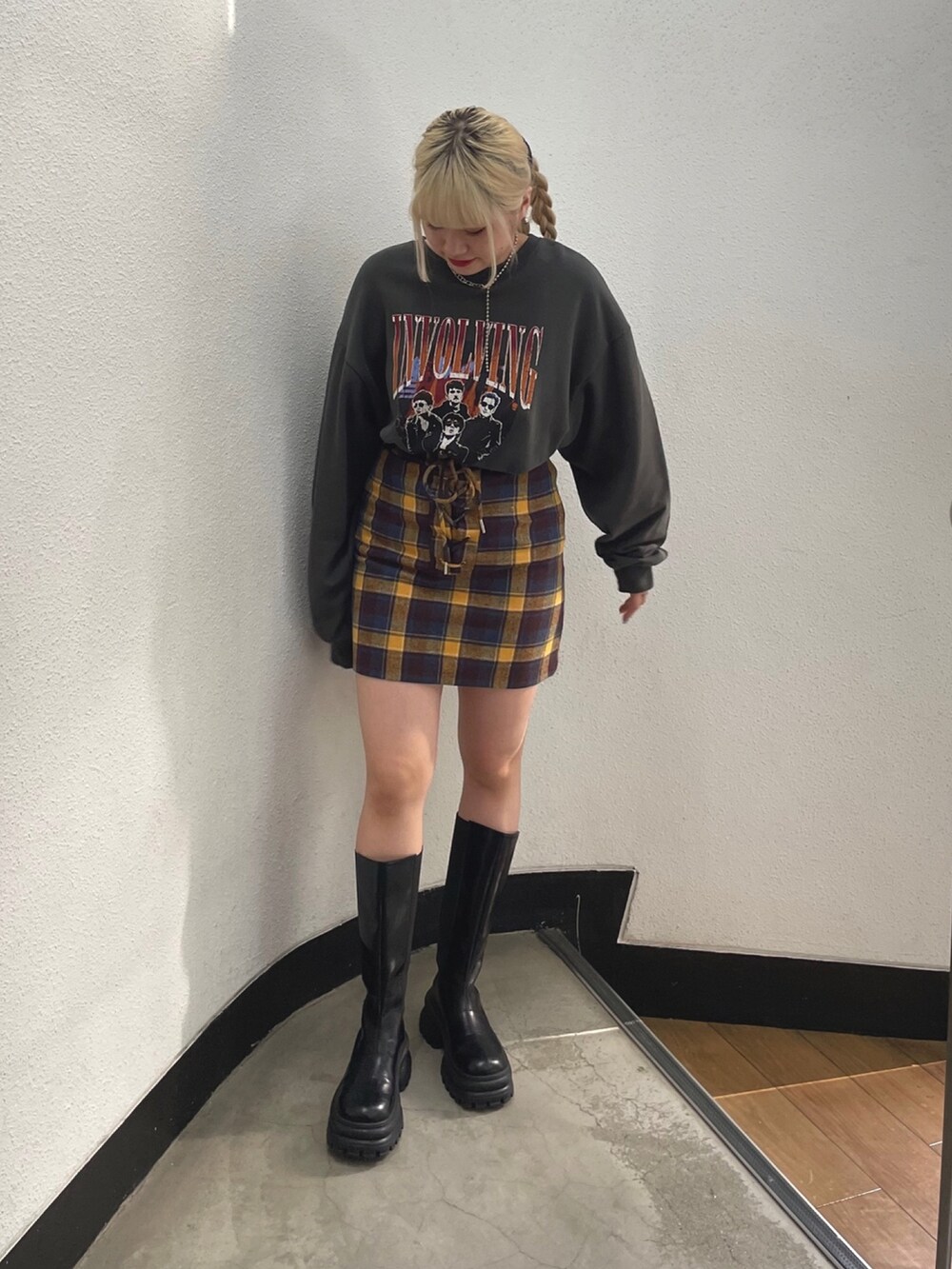 ブラック系のスウェット、イエロー系のスカートを着用したレディースの夏コーディネートの2枚目の写真