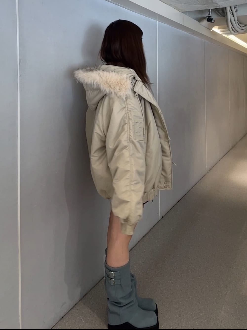 ホワイト系のブルゾン、ブラウン系のカーディガン/ボレロ、ブルー系のブーツを着用したレディースの秋コーディネートの2枚目の写真