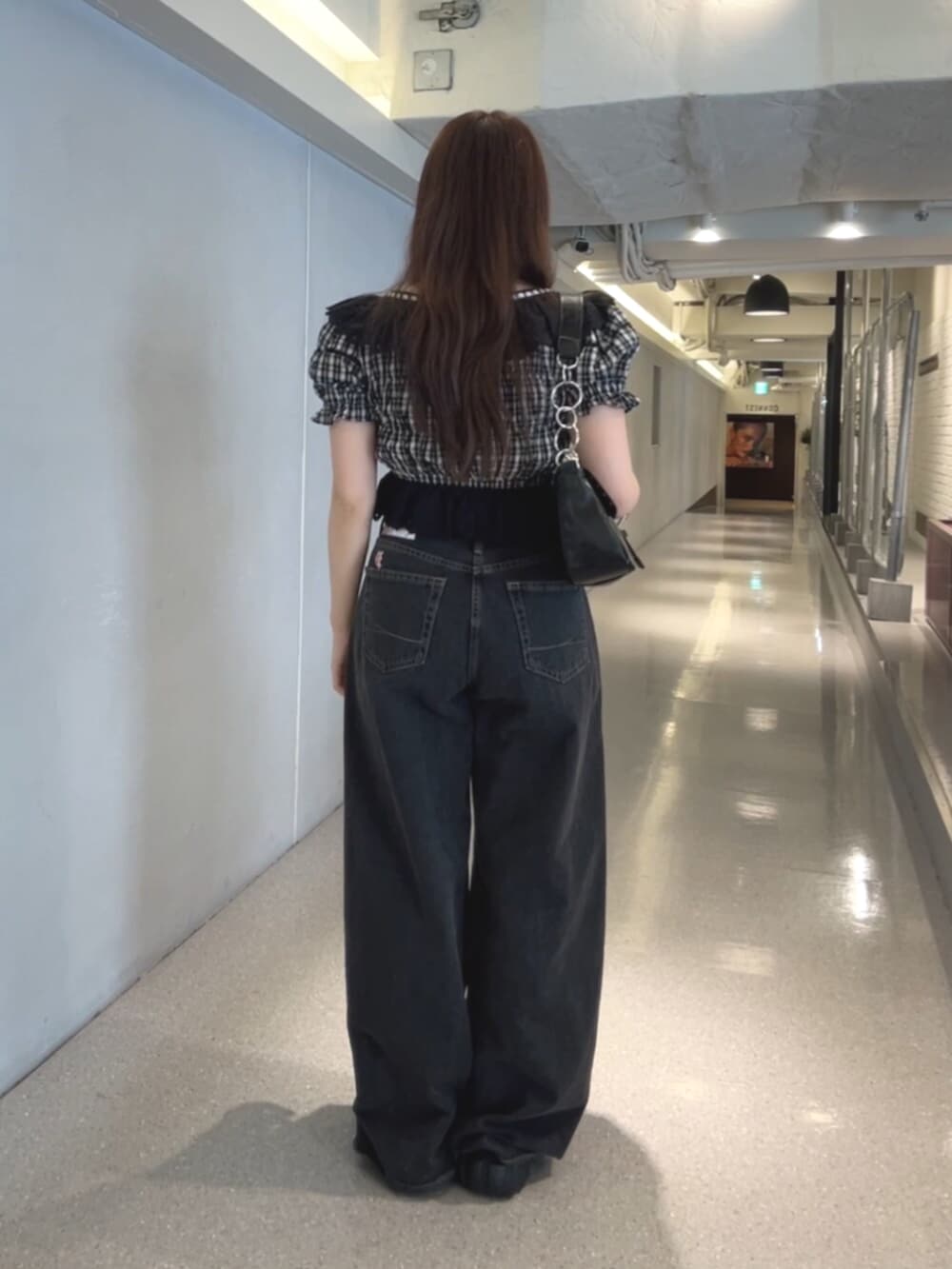 ブラック系のハンドバッグ、ブラック系のデニムパンツ、ブラック系のシャツ/ブラウスを着用したレディースの春コーディネートの3枚目の写真