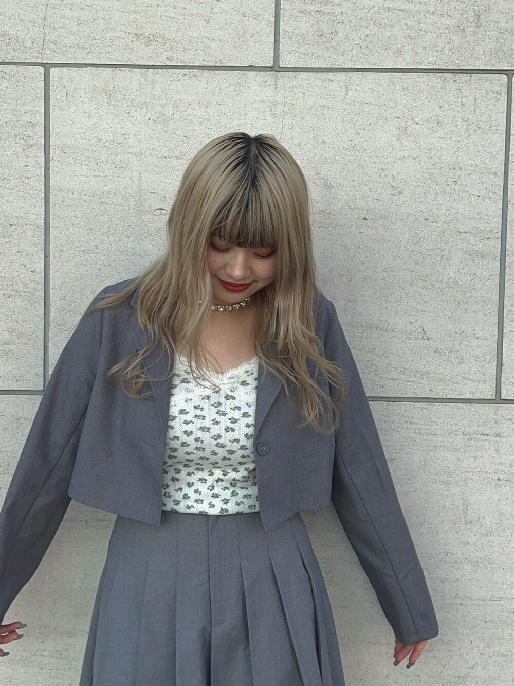 グレー系のテーラードジャケット、グレー系のスカート、ブラック系のブーツを着用したレディースの冬コーディネートの2枚目の写真