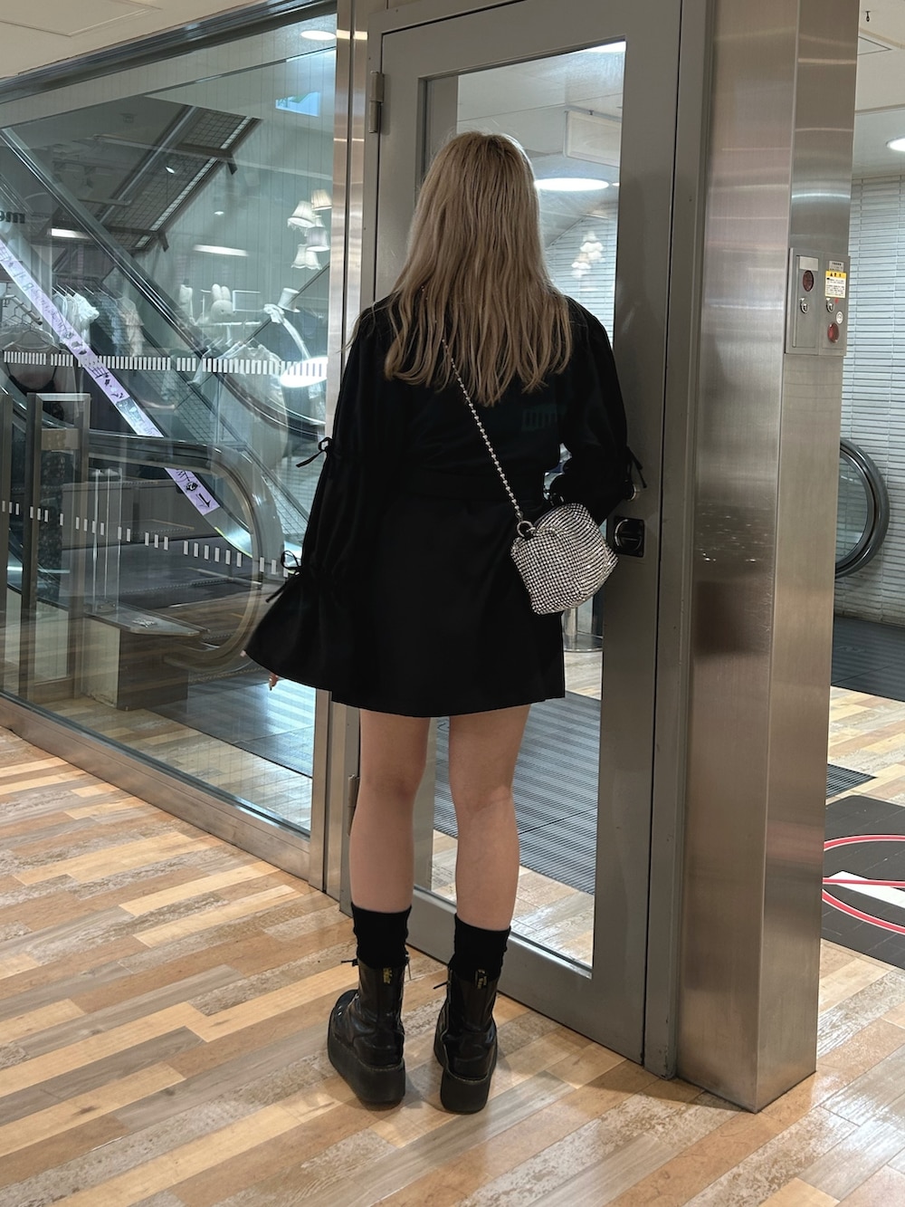 ブラック系のワンピース、シルバー系のTシャツ/カットソー、ホワイト系のショルダーバッグを着用したレディースの秋コーディネートの2枚目の写真