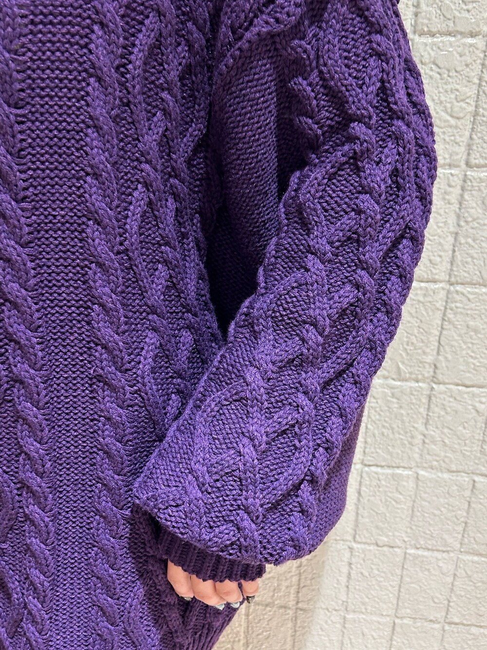 ブラック系のボストンバッグ、ブラック系のブーツ、パープル系のニット/セーターを着用したレディースの秋コーディネートの6枚目の写真