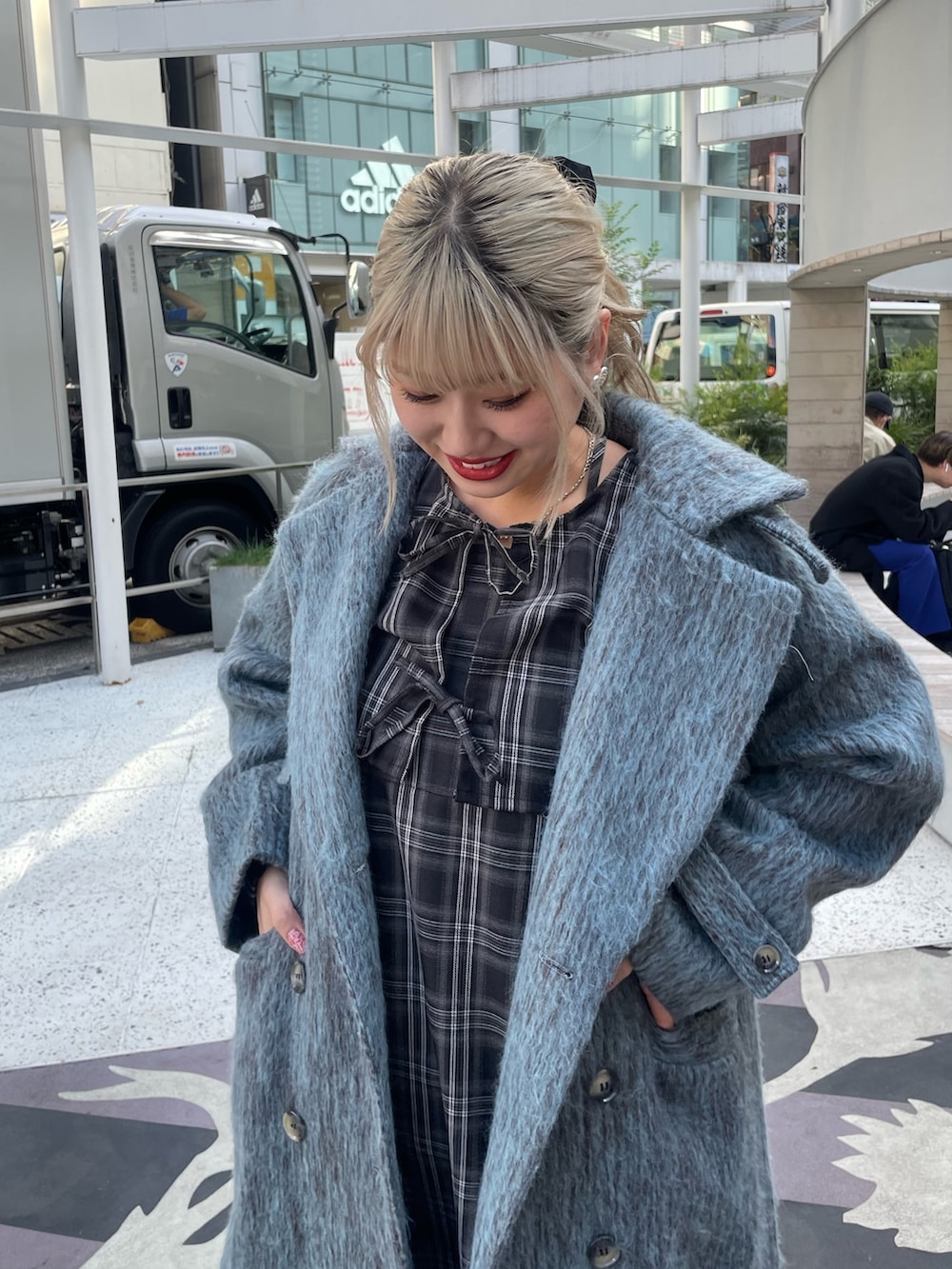 ブルー系のチェスターコート、ブラック系のワンピース、ブラック系のその他シューズを着用したレディースの冬コーディネートの4枚目の写真